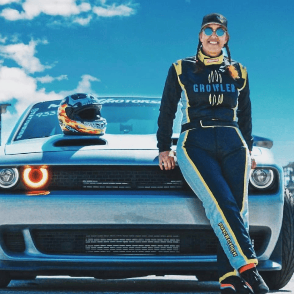 Woman in custom racing suit leaning on car
