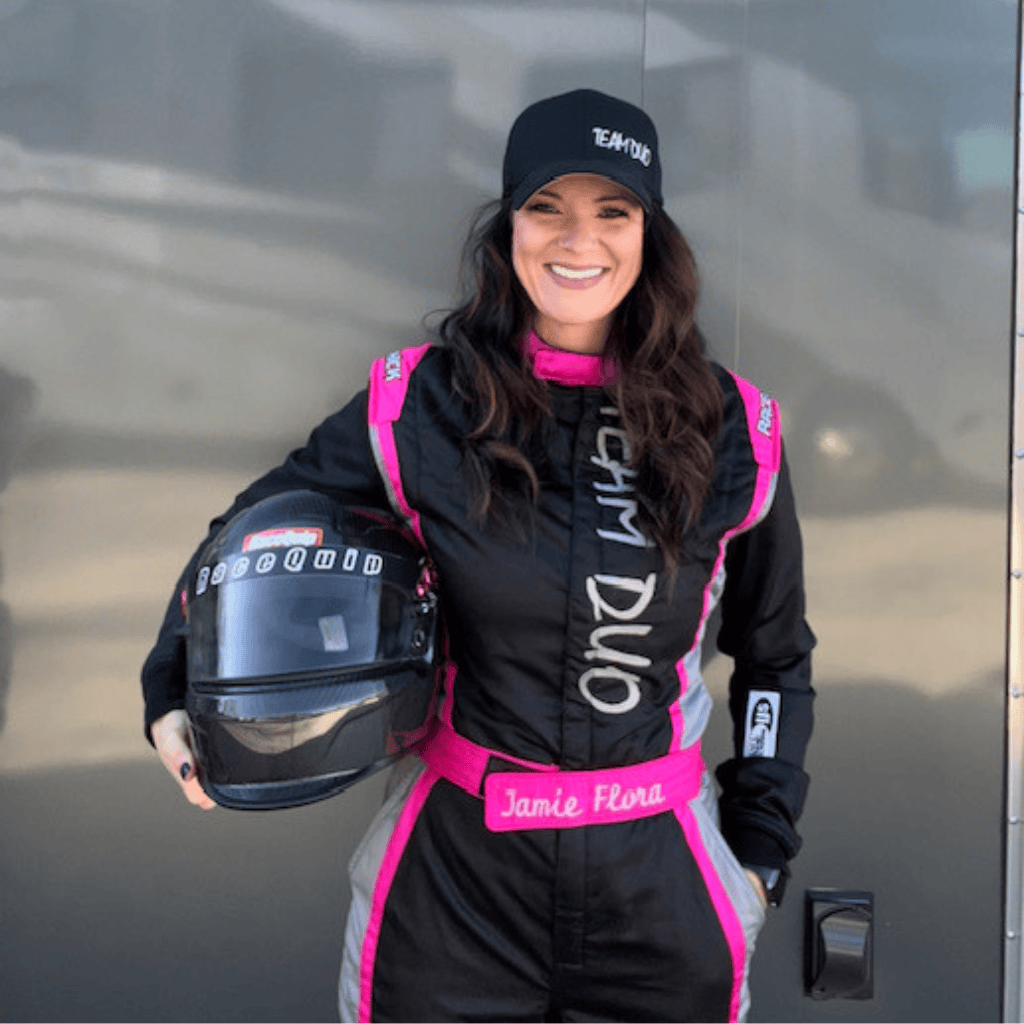 Woman in Nomex racing suit holding helmet