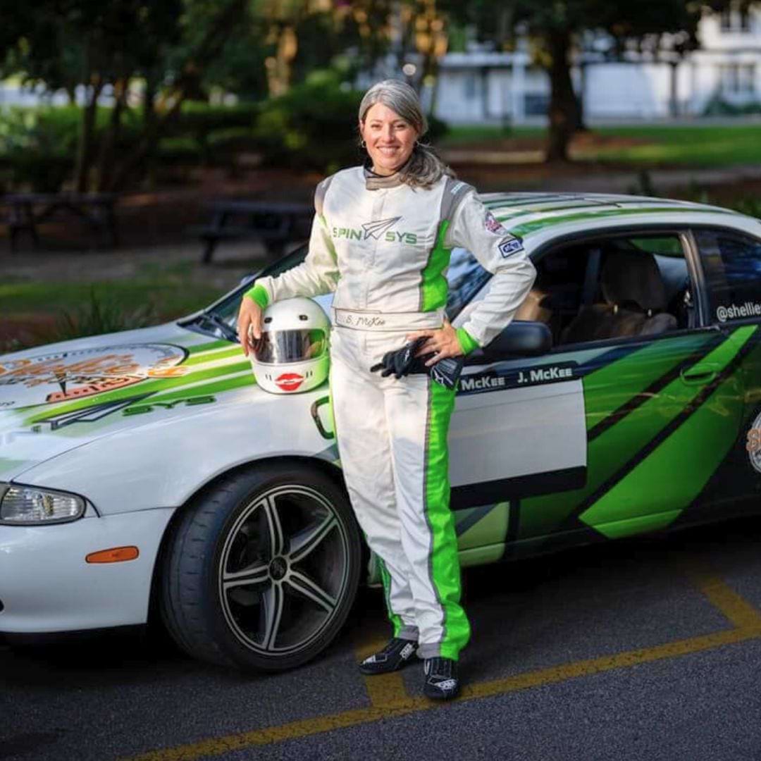 Racechick in custom racing suit with her car