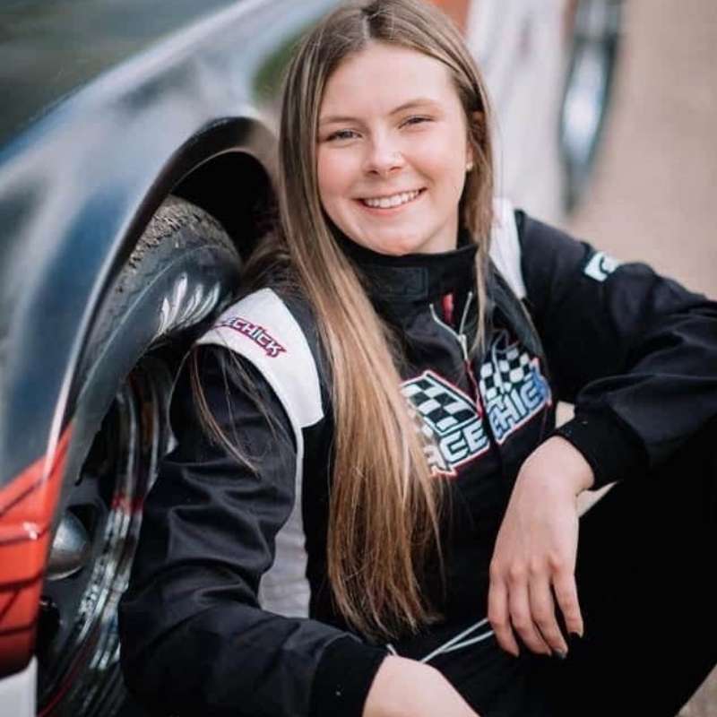 Race car driver smiling next to car, design 83