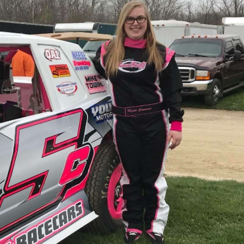 Race car driver in racing suit with car.