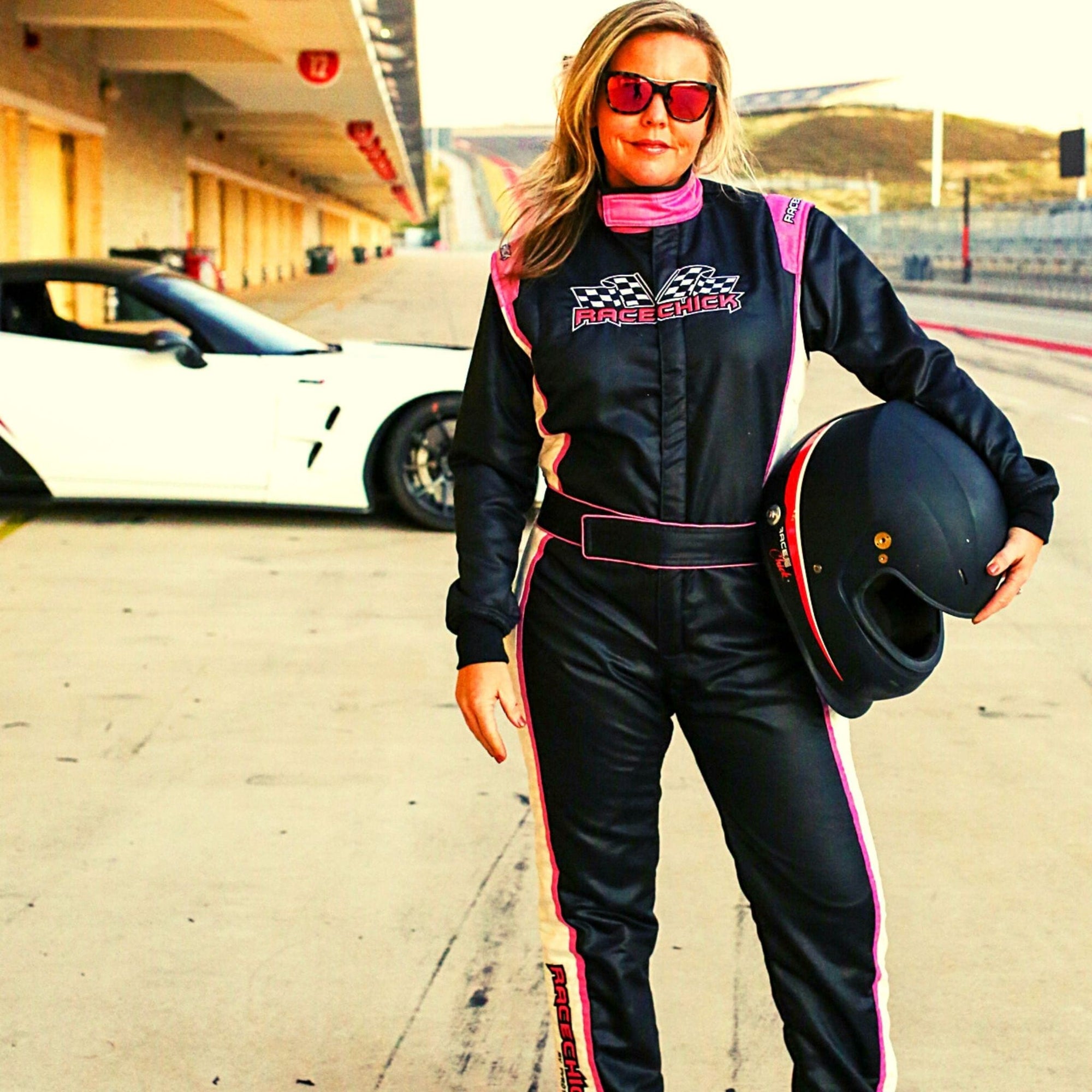 Woman wearing SFI 3.2A/5 Rated Women's Auto Racing Fire Suit Black Pink Race Suit
